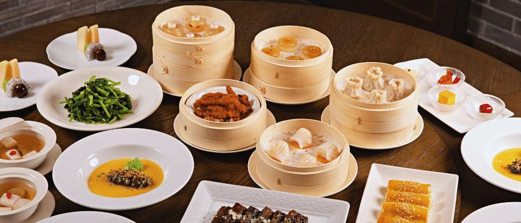Une table garnie d'un assortiment de dim sum traditionnels servis dans des paniers en bambou