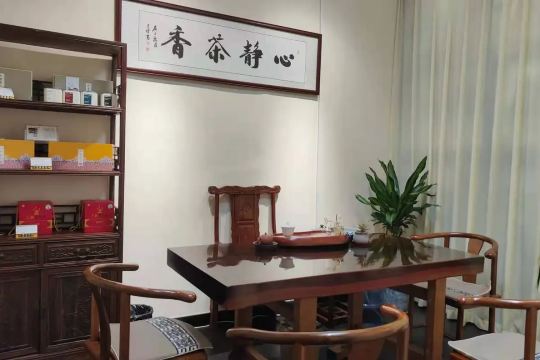 Chinese tea room with a wooden tea table, tea sets, and a calligraphy sign