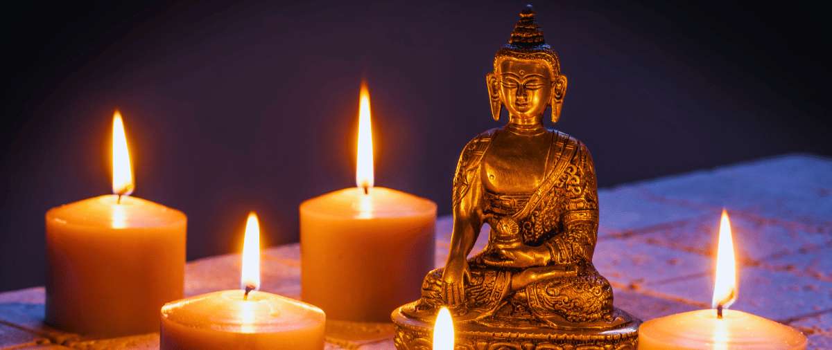 Golden Buddha statue surrounded by lit candles
