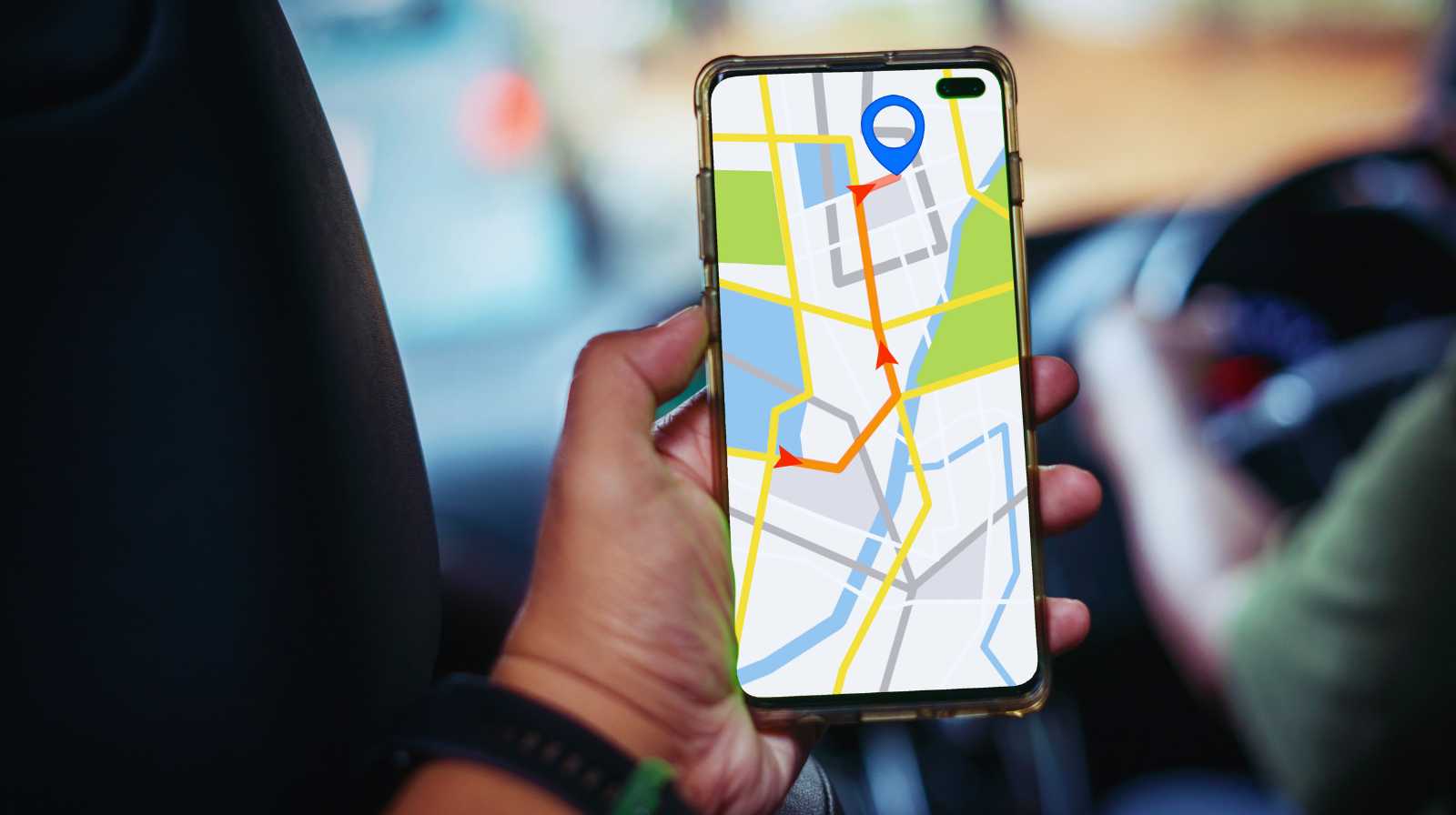 Persona sosteniendo un móvil con una aplicación de mapas mostrando una ruta de navegación en la ciudad