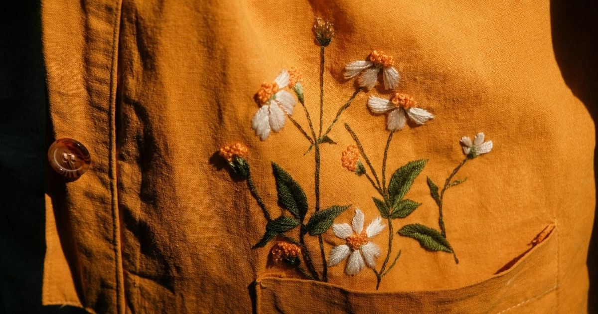 Bordado tradicional con motivos florales sobre tejido, ejemplo de artesanía típica de la región de Chongqing.