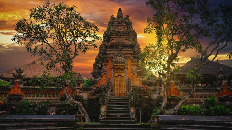 Templo balinés al atardecer con arquitectura tradicional y cielo iluminado en tonos cálidos