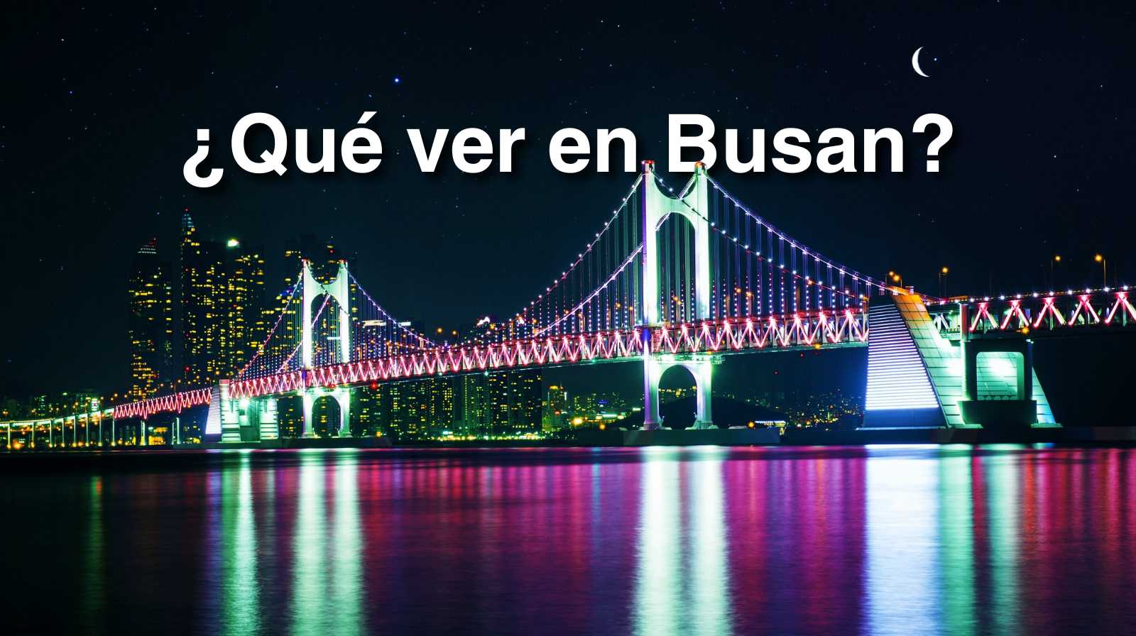 Puente Gwangan en Busan iluminado con luces de colores reflejadas en el agua durante la noche