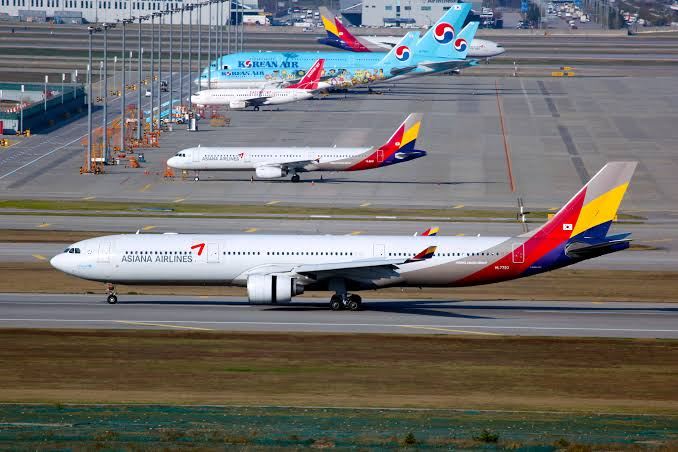 Korean Air and Asiana Airlines aircraft on the runway at an airport in South Korea.