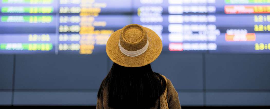 A traveller checking the airport departure board before an international flight