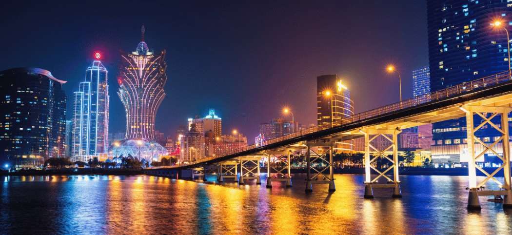 Vista nocturna del distrito moderno de Macao con casinos, hoteles y rascacielos iluminados