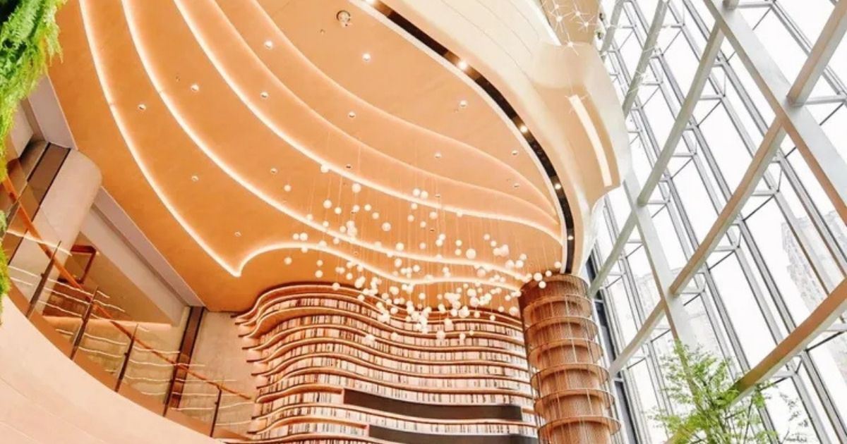 Interior del centro comercial The Ring en Chongqing, con diseño moderno, grandes ventanales y elementos vegetales.