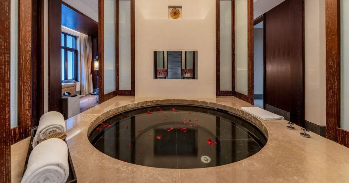 Zimmer mit privatem Thermalbecken, dekoriert mit Blütenblättern, im Huaqing Palace Resort & Spa in Xi’an. 