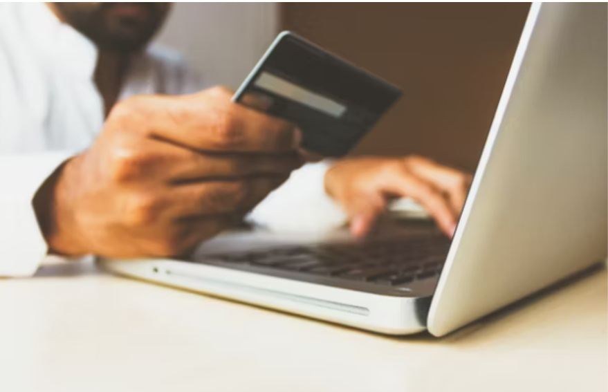 Man using credit card at laptop 