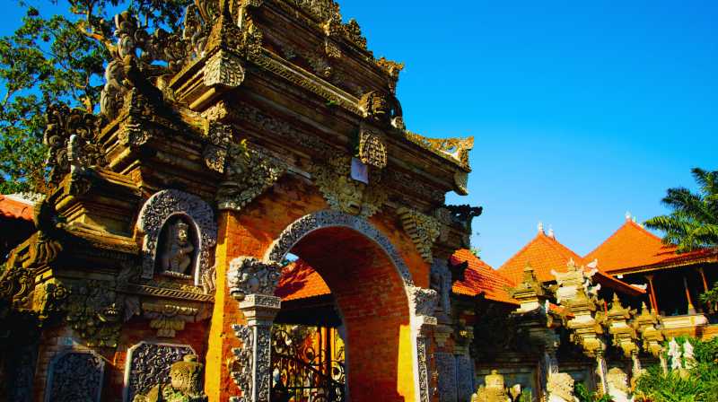 Puerta monumental de templo balinés con relieves tallados y tejados tradicionales
