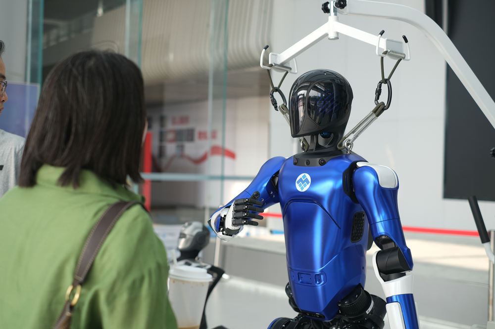 Humanoid robot interacting with a visitor at an indoor facility