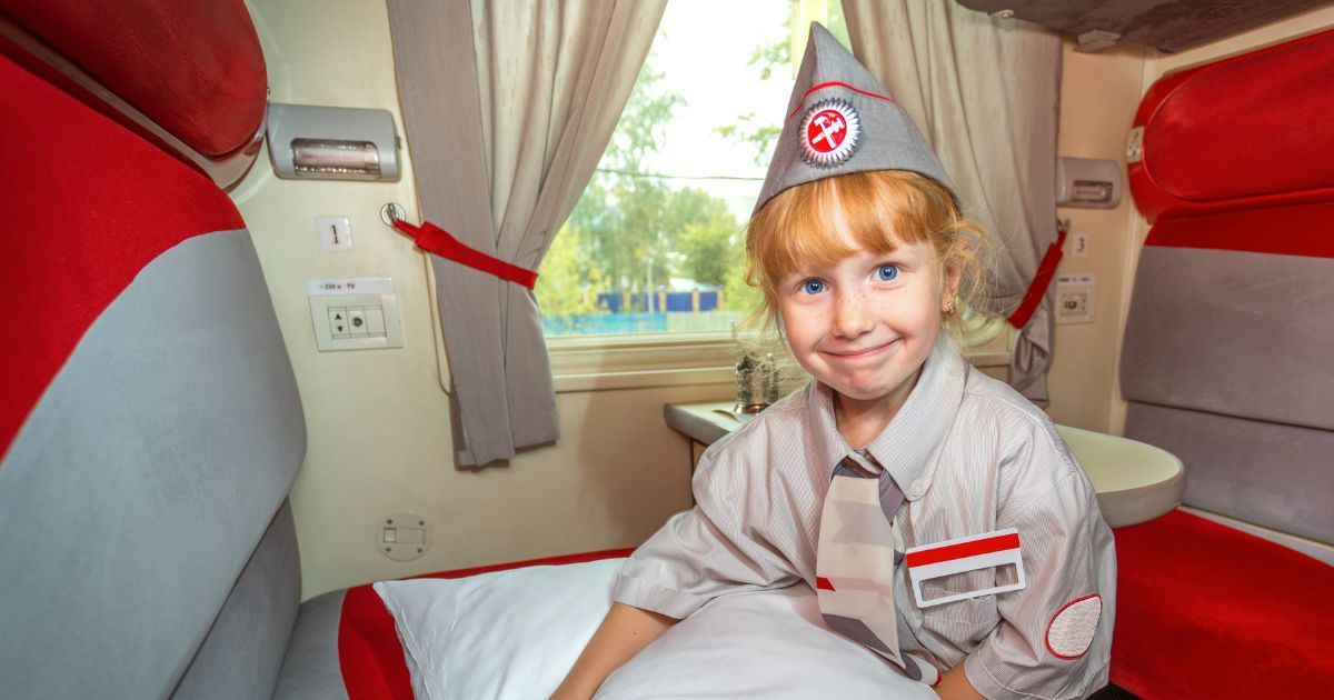 A small child sitting in a sleeper train