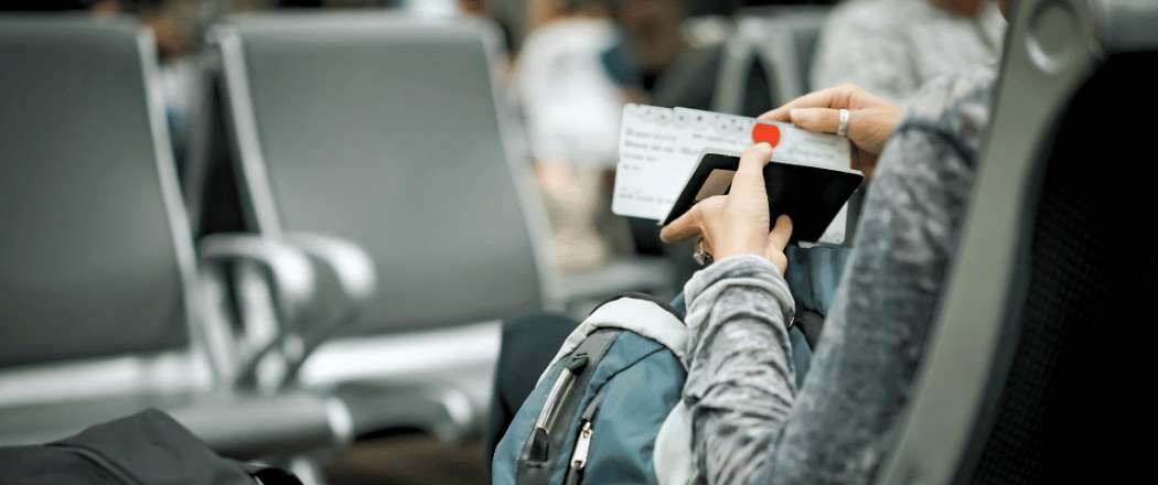 Viaggiatrice che tiene in mano la carta d'imbarco nella sala d'attesa prima di volare in Turchia