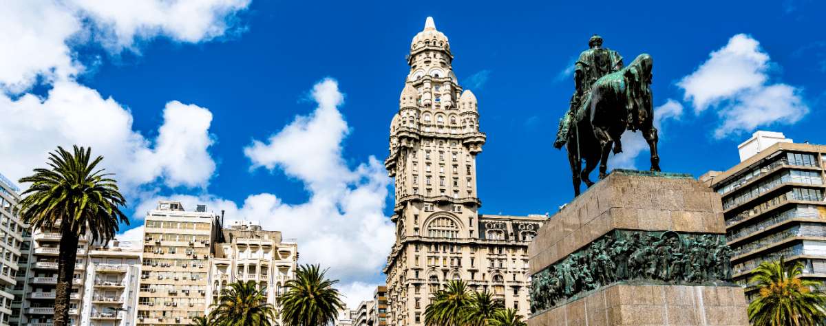 Plaza histórica en Montevideo con Palacio Salvo y monumento ecuestre bajo cielo despejado