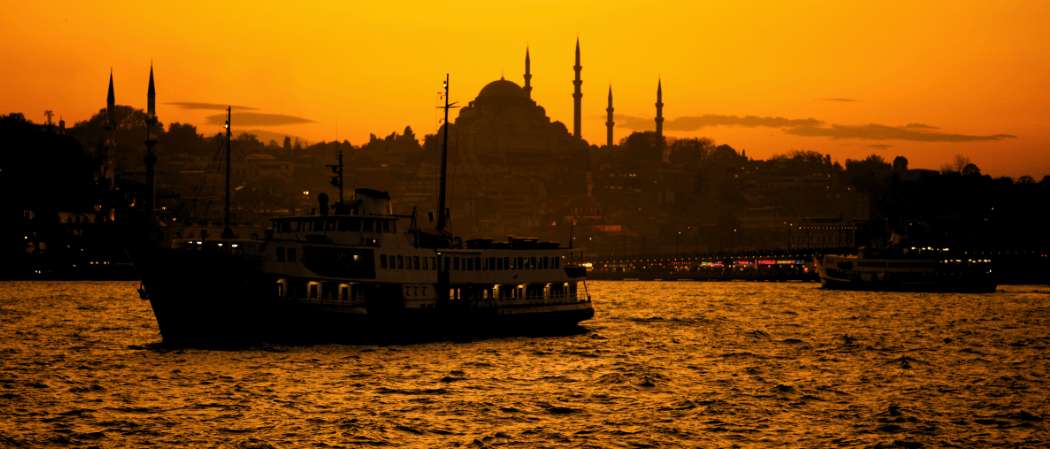 Traghetto che naviga davanti al profilo di Istanbul al tramonto durante un viaggio turistico in Turchia