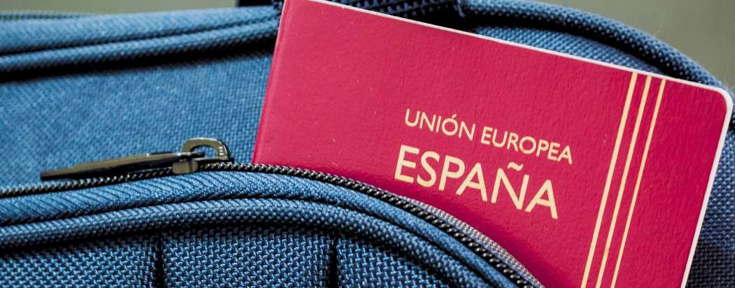 Passeport espagnol sur une valise bleue pour partir en Indonésie depuis l'Espagne