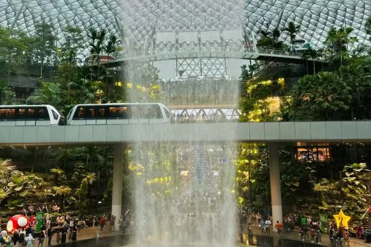 HSBC Rain Vortex and Skytrain surrounded by greenery at Jewel Changi Airport