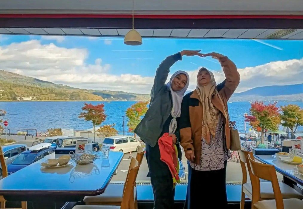 Travelers enjoying Lake Kawaguchiko views from a lakeside restaurant