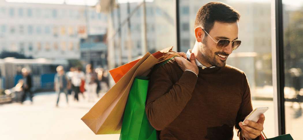 Turista consultando el móvil mientras pasea por una zona comercial de Shanghái