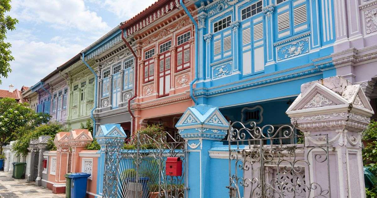 Casas Peranakan de colores con fachadas ornamentadas y contraventanas tradicionales en Singapur.