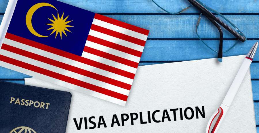 Bandera de Malasia junto a pasaporte y formulario de solicitud de visa para preparar un viaje internacional