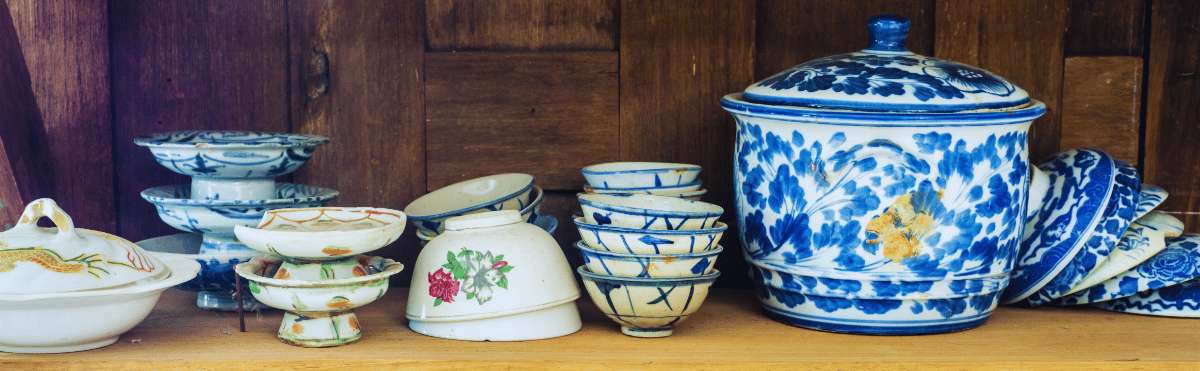 Collection of blue and white porcelain pieces of various sizes on a wooden shelf