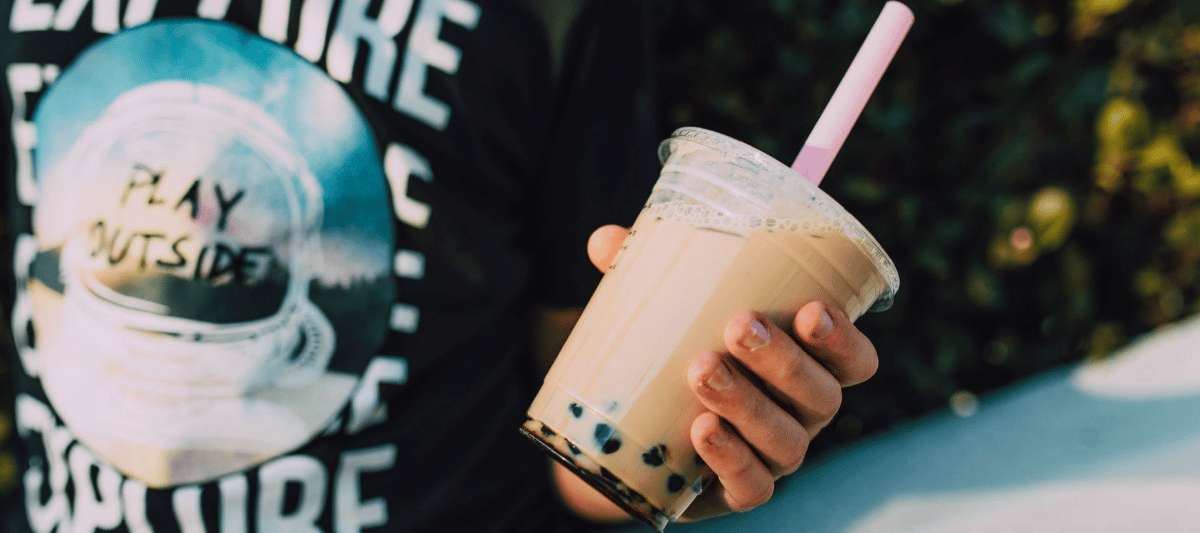 Bubble tea con leche y perlas de tapioca en vaso plástico con sorbete