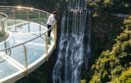 Glass viewing platform overlooking a forest waterfall