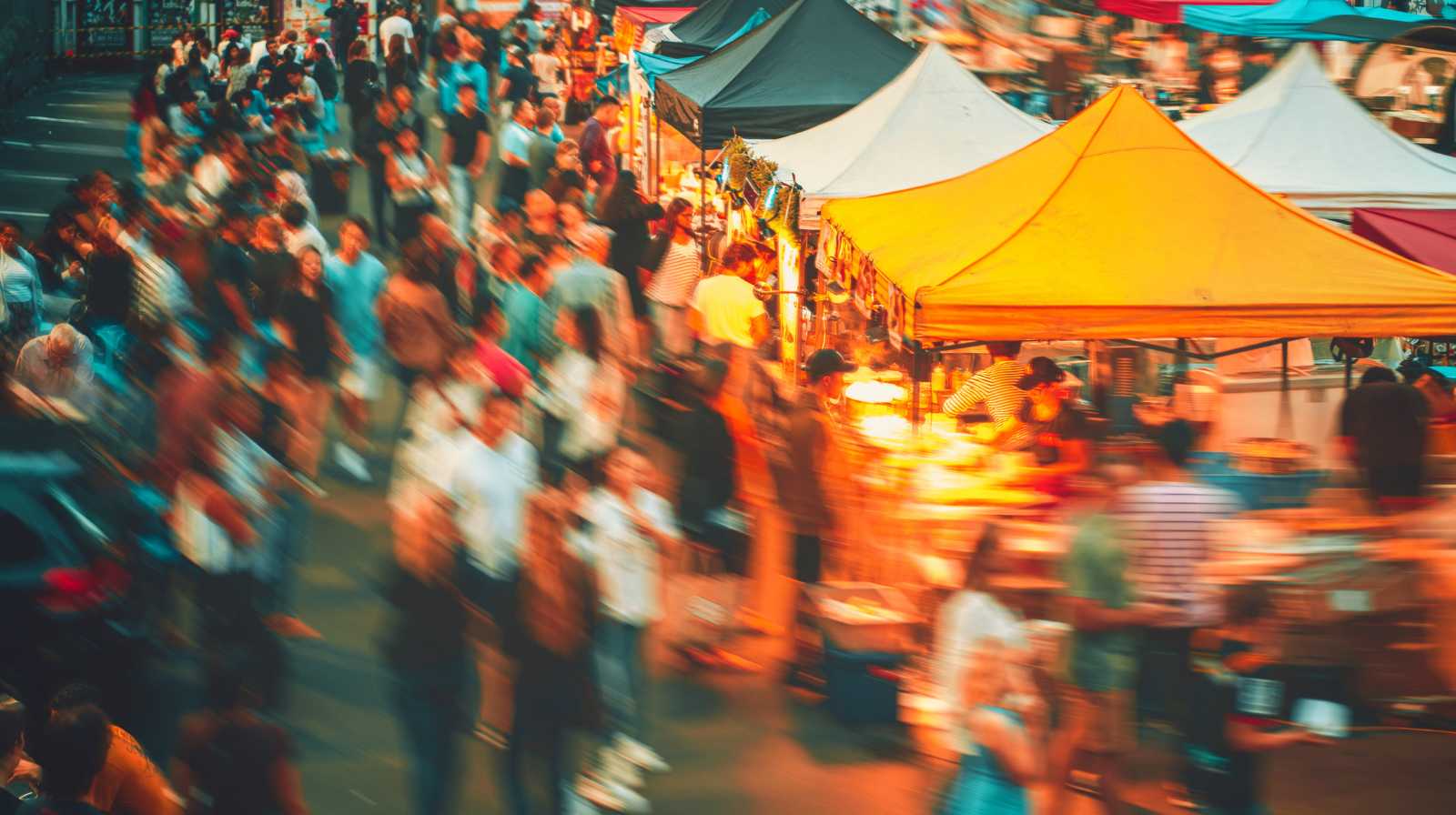 Mercado nocturno en China con puestos iluminados y gran afluencia de gente