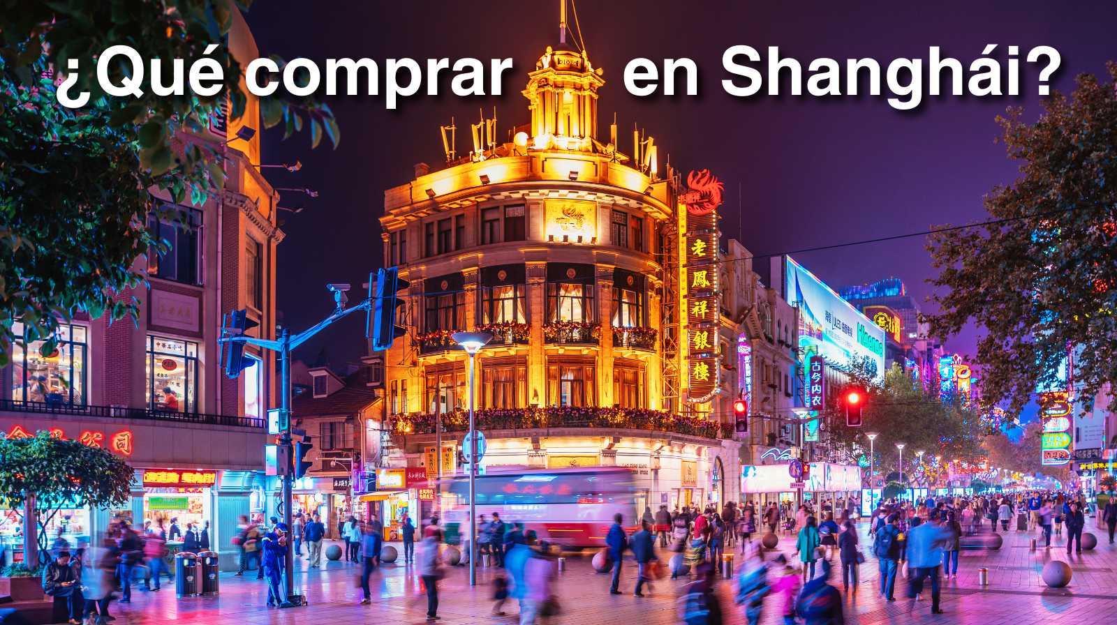 Calle comercial de Shanghái de noche, llena de luces, tiendas y gente paseando