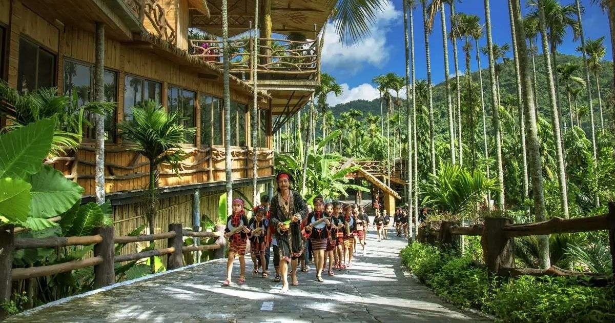 Visitantes con vestimenta tradicional recorriendo el Poblado Étnico Binlang, en Hainan.