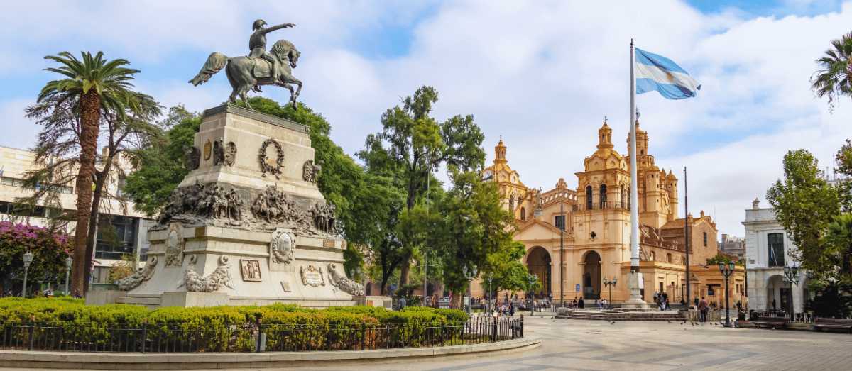 Plaza histórica en Córdoba, Argentina, con estatua ecuestre y catedral al fondo