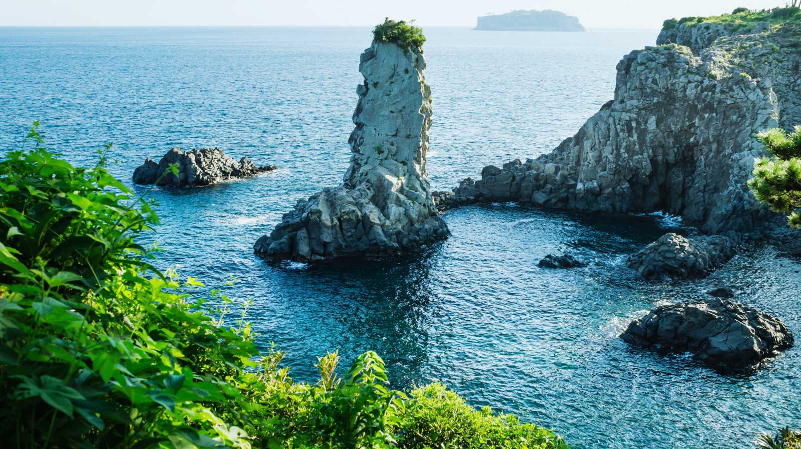 Formaciones rocosas volcánicas en los acantilados de Jusangjeolli en Jeju con el mar azul alrededor