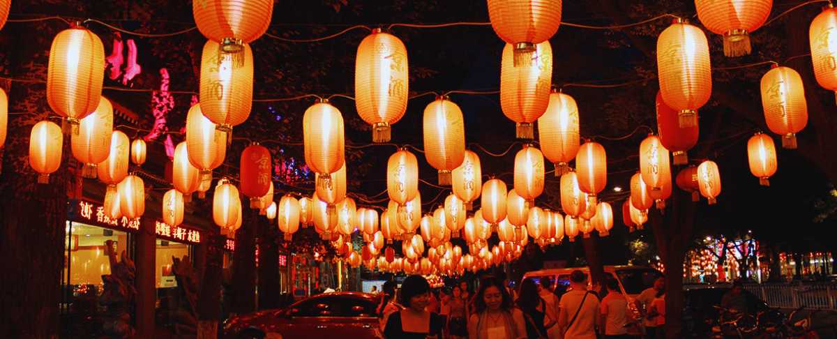 Calle decorada con faroles rojos durante la noche en Pekín, ambiente tradicional chino