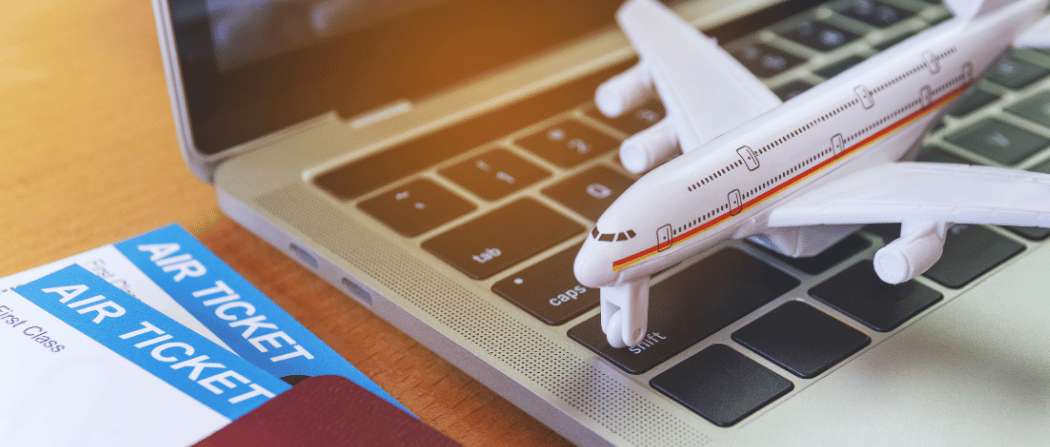Biglietti aerei e modellino di aereo su un portatile durante la pianificazione di un viaggio in Corea del Sud