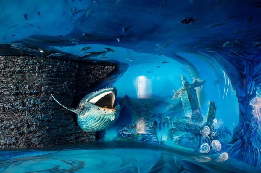 Underwater aquarium exhibit with a whale shark and marine life