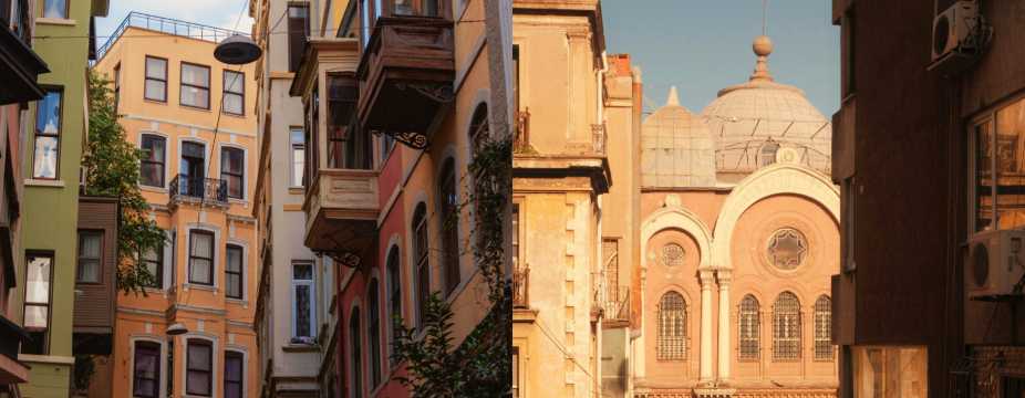 A narrow Istanbul street with colourful historic buildings and traditional balconies.