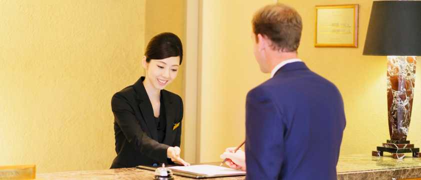 Hotel receptionist assisting a guest at the reception desk