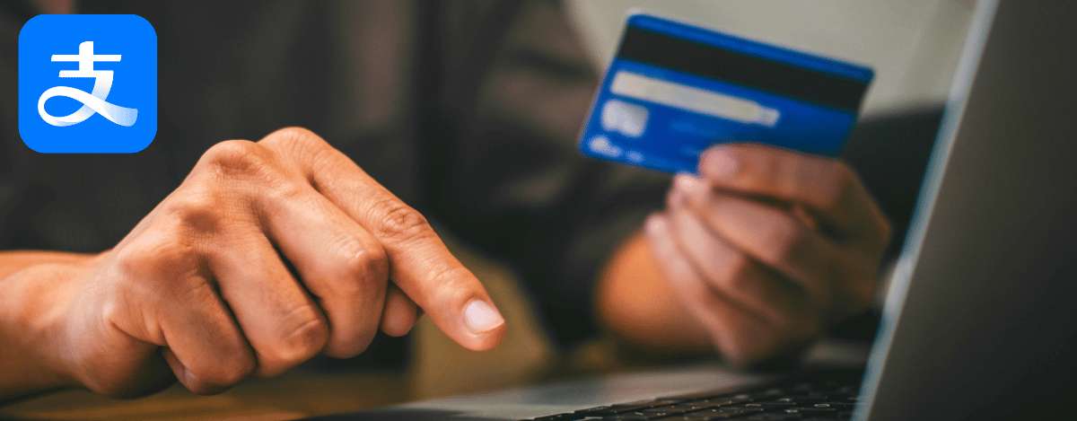 Nutzer beim Online-Einkauf mit einer mit Alipay verknüpften Bankkarte auf dem Laptop