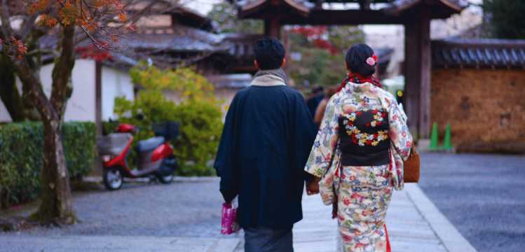Couple se promenant dans une rue japonaise en tenue traditionnelle kimono dans une atmosphère paisible