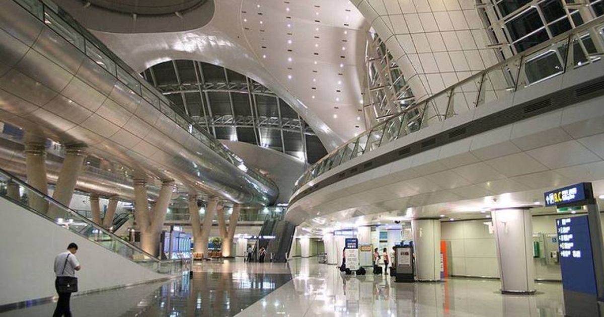 Interior of a modern airport terminal with high ceilings and passenger walkways.
