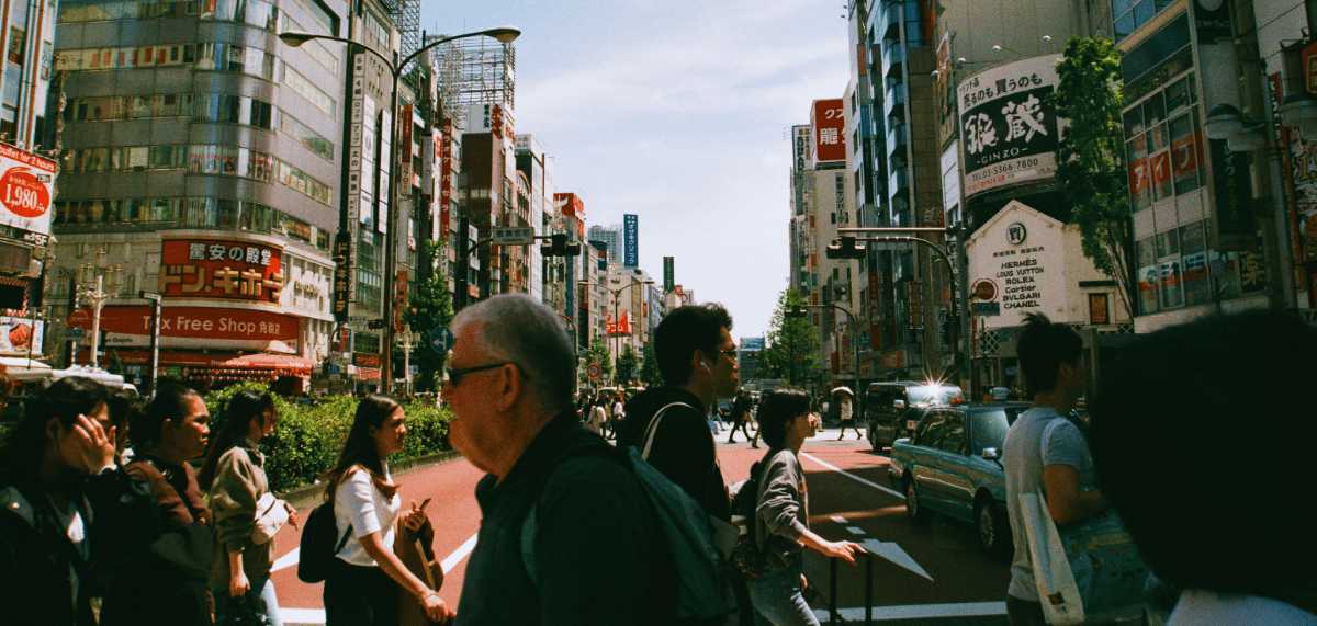 Calle concurrida en Tokio con peatones cruzando entre rascacielos y carteles en japonés en pleno centro urbano