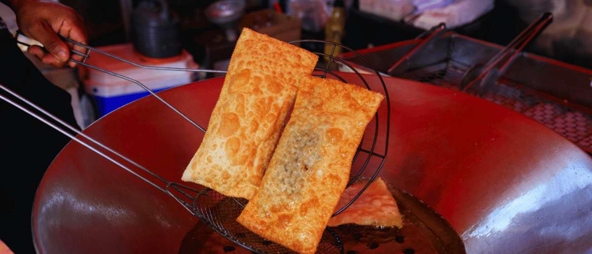 Comida callejera china frita en wok con empanadillas crujientes recién hechas