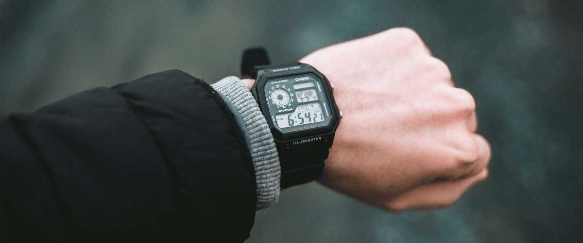 Schwarze digitale Casio-Uhr am Handgelenk einer Person mit dunkler Jacke