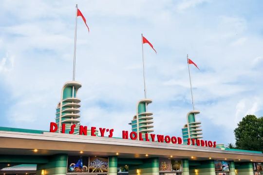 Entrance to Disney's Hollywood Studios with the park sign and flags