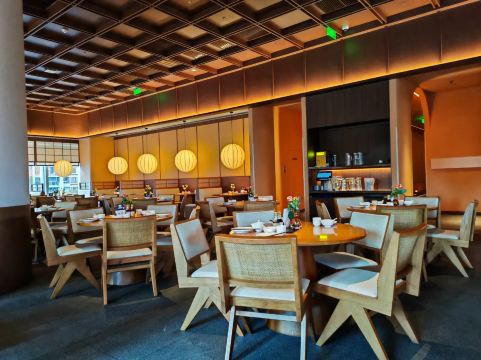 Warmly lit restaurant dining room with round tables