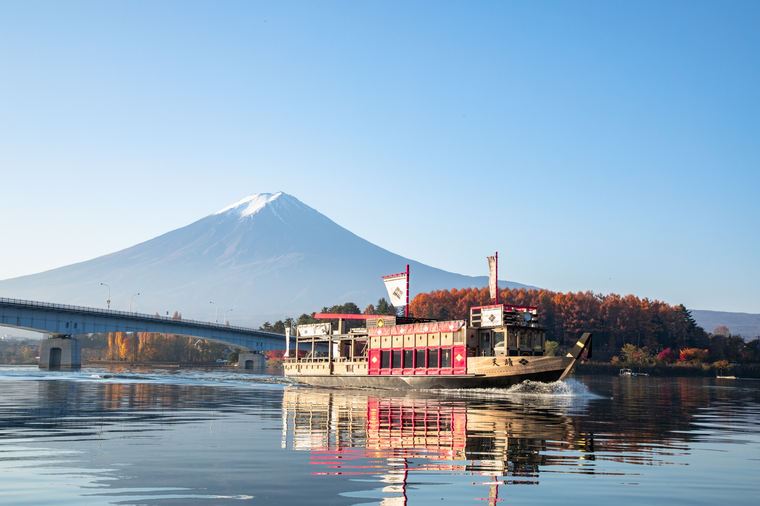 Sightseeing boat cruising across Lake Kawaguchi with Mount Fuji in the background