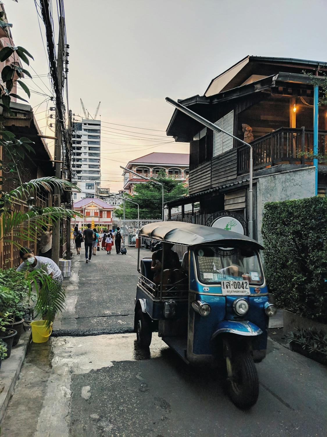 A tuk tuk parked in the middle of a quiet road