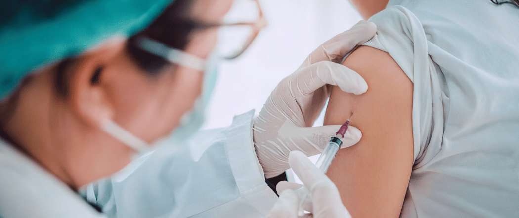 Persona che riceve un vaccino prima di viaggiare all'estero come preparazione sanitaria per la Corea del Sud
