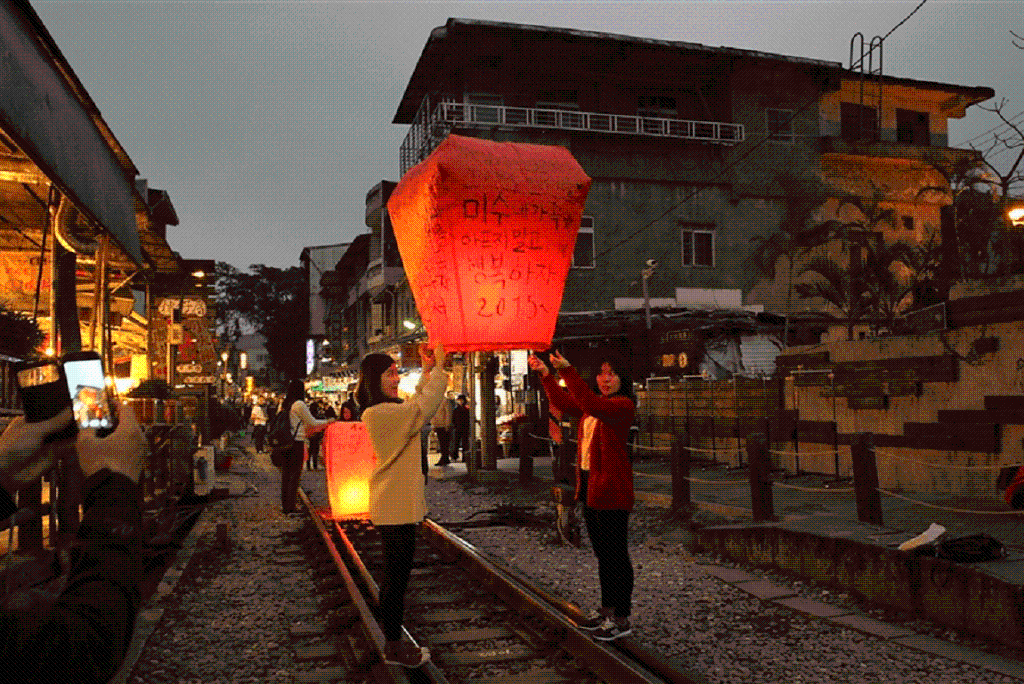 A couple of ladies releasing a lantern into the skies of shifen in the evening